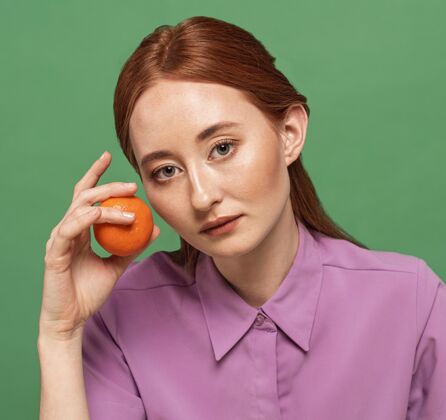 构图美丽的红发女人摆着橘子的姿势女人水果饮食