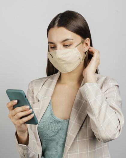 科技肖像时尚的女人用手机带面具手机防护女性