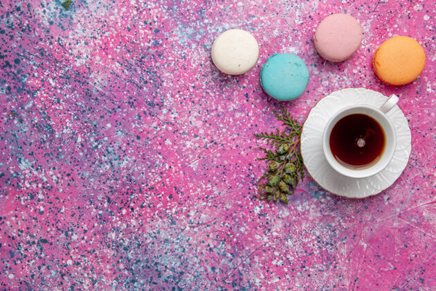 茶顶视图一杯茶与五颜六色的法国麦卡龙淡粉色墙壁蛋糕饼干糖甜派茶蛋糕浅粉色景观