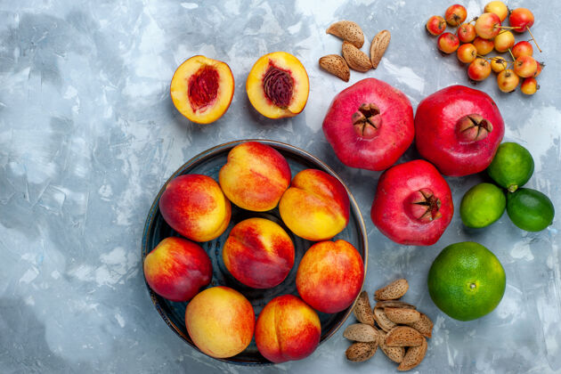 核果顶视图新鲜桃子美味的夏季水果与橘子和柠檬在浅白色的办公桌上食物健康醇香