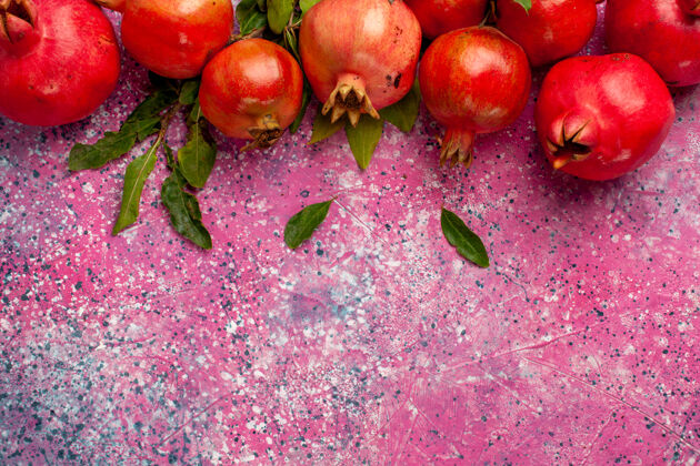 叶顶上近距离观赏新鲜红石榴 绿叶上有粉红色的墙壁 果色鲜美 果汁醇厚鲜色闭
