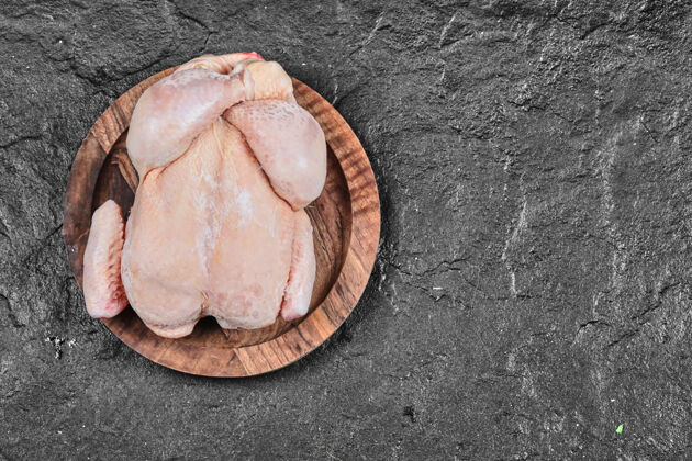 鸡把生的整只鸡放在白色的陶瓷板上烹饪杂货肉鸡