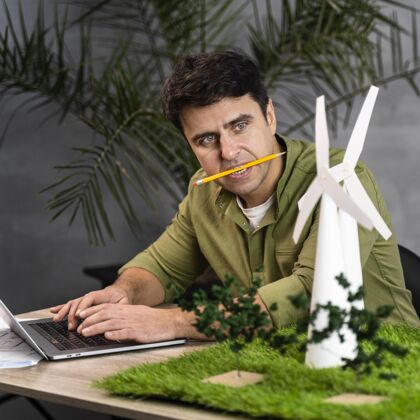 环境嘴里叼着铅笔的人在做一个环保型风力发电项目工程师环保技术专家