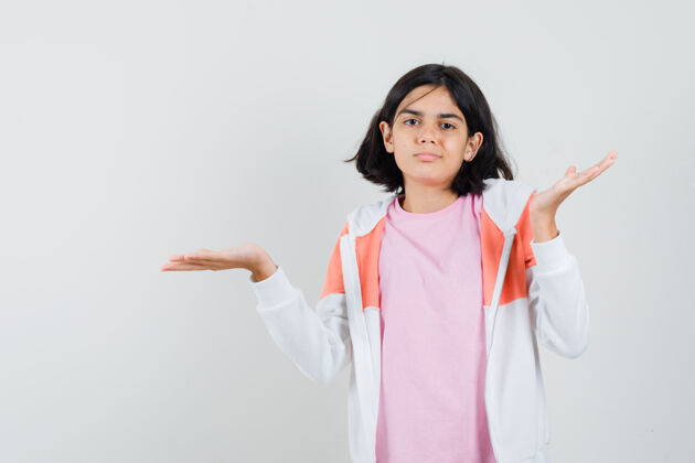 无助十几岁的女孩穿着夹克 粉色衬衫 表现出无助的姿态 看上去很不满在一起情绪表演