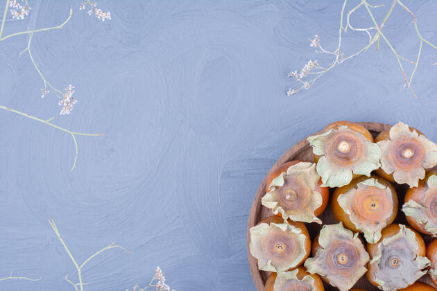 植物把李子放在蓝色背景的木盘里清淡甜味美味