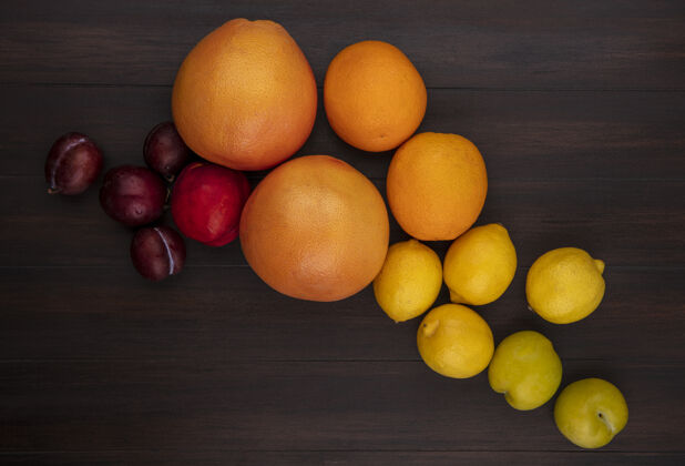柚子顶视图樱桃李子与柠檬橙子葡萄柚和桃子在木制背景上桃橘子李子
