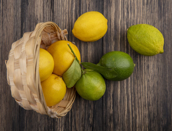 新鲜顶视图柠檬与柠檬在一个倒置的篮子木制背景酸橙景观逆变器