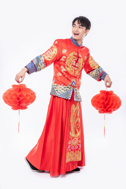 红灯笼穿旗袍西服的男人在过年的时候到他店里装饰红灯中国民族旗袍传统
