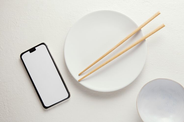 陶器顶视图安排优雅的餐具与智能手机移动的桌子组合的