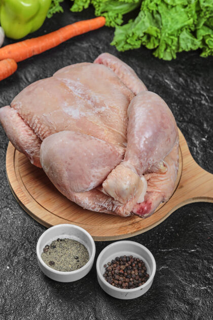香料生的整只鸡放在木板上 配上蔬菜和香料板饮食肉