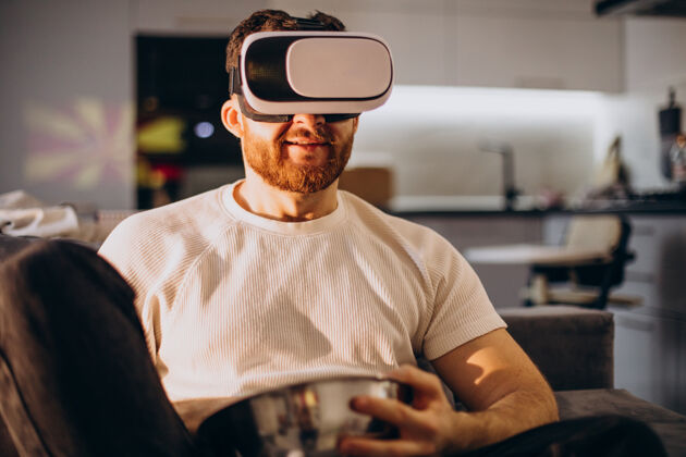 虚拟现实耳机坐在家里使用虚拟现实的男人应用人虚拟现实