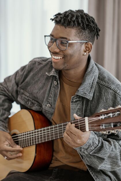 艺术家笑脸男音乐家在家弹吉他房子创意垂直