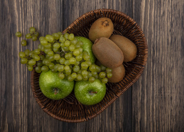 水果顶视图绿色葡萄与苹果和猕猴桃在一个木制的背景篮子食物篮子顶部