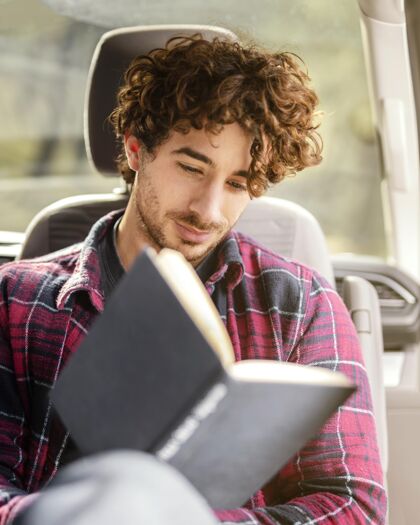 旅行中枪男人在车里看书公路旅行年轻冒险