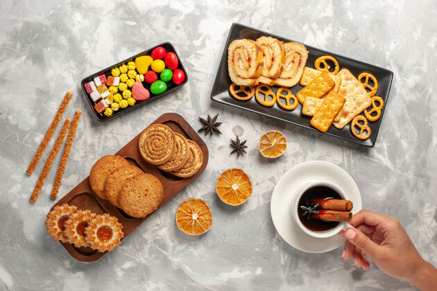 糖果俯瞰不同的饼干 在白色桌面上放上糖果和一杯茶饼干饼干糖烤蛋糕甜馅饼烘焙早餐生的