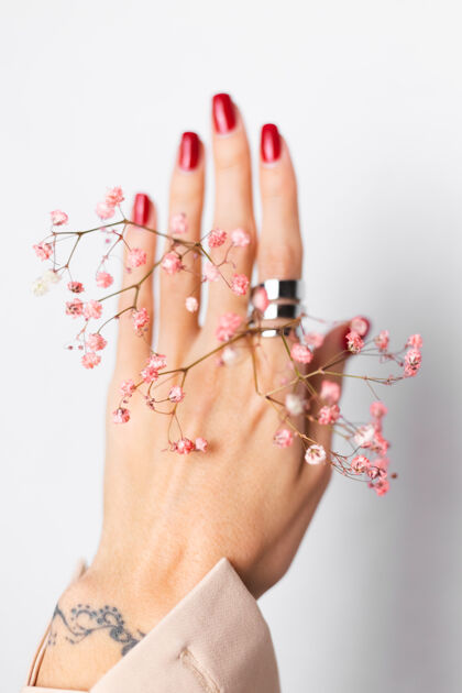 博客柔美温柔的照片 女人手上戴着大戒指 红色的指甲 手上拿着可爱的粉色干花自然最小皮肤