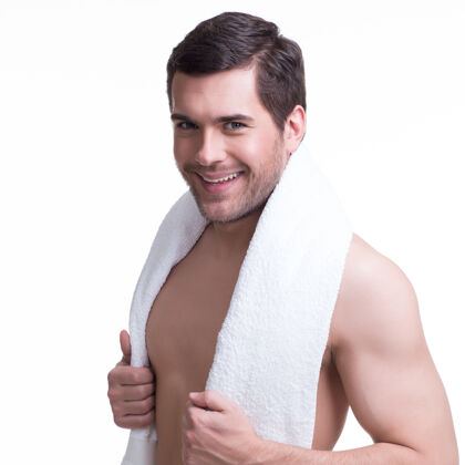 毛巾一个面带微笑的年轻帅哥的肖像 拿着一条毛巾-白色的隔离带站着牙齿年轻