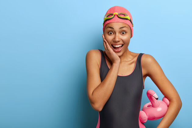 放松微笑快乐的女人穿着游泳服和橡胶泳衣训练充气泳装
