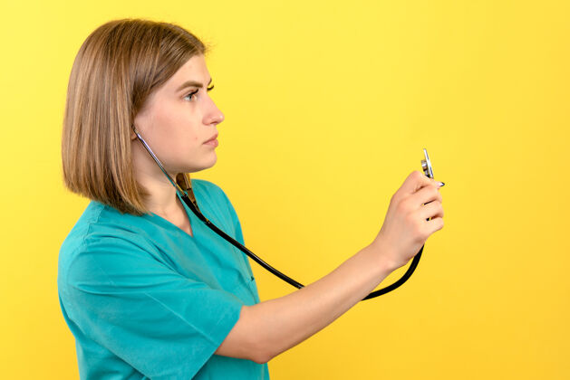 秘书黄色墙上带眼压计的女医生的正视图听诊器前面血压计