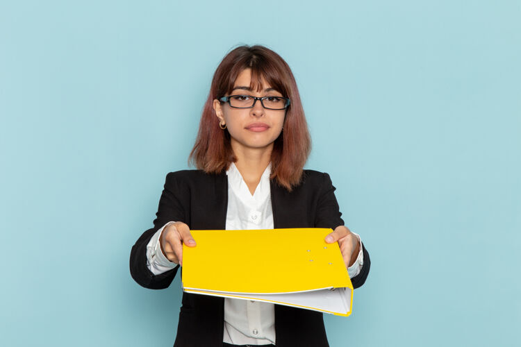 电脑正面图蓝色表面上拿着黄色文件的女上班族工人女性忙