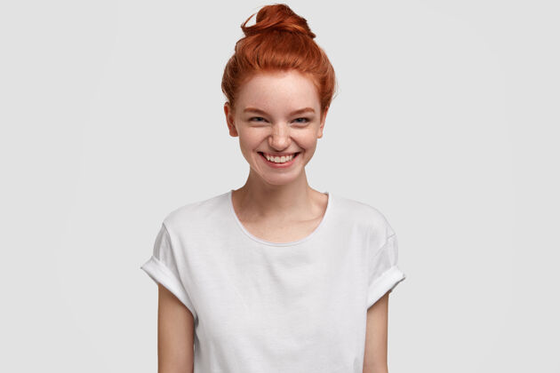快乐快乐可爱的红发少女照片微笑着好奇和感兴趣的表情 接受精彩的提议 穿着休闲白色t恤 室内模特雀斑休闲生姜