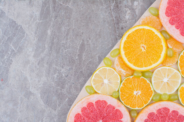 柠檬把柑橘水果片和葡萄放在木板上新鲜柚子葡萄