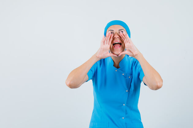 女人女医生穿着蓝色制服大声喊叫或宣布某事 看上去很高兴正视图喊叫诊断疾病