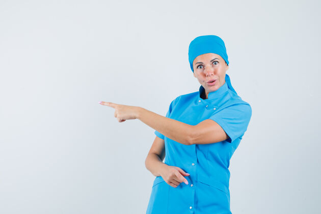 妇女女医生指着身穿蓝色制服的一侧 神情犹豫不决前视图治疗护士指点