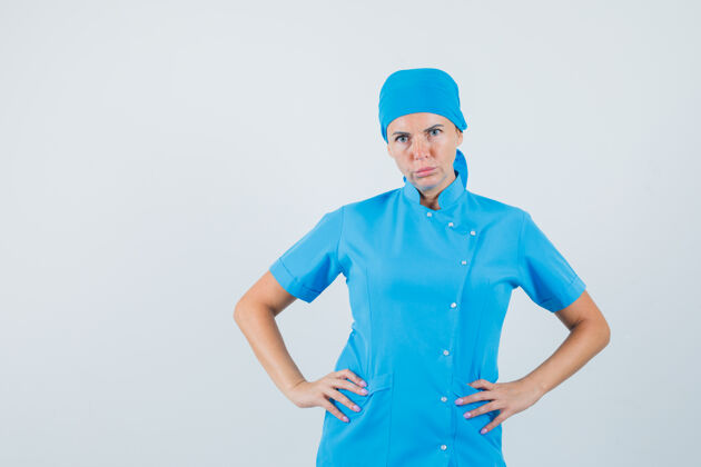 预防女医生穿着蓝色制服 手放在腰上 表情严肃 正前方制服严重诊所