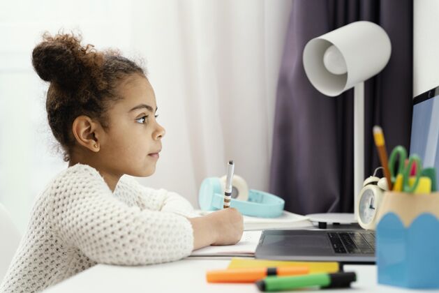 网络女孩在家使用笔记本电脑上在线学校的侧视图课程学习在线