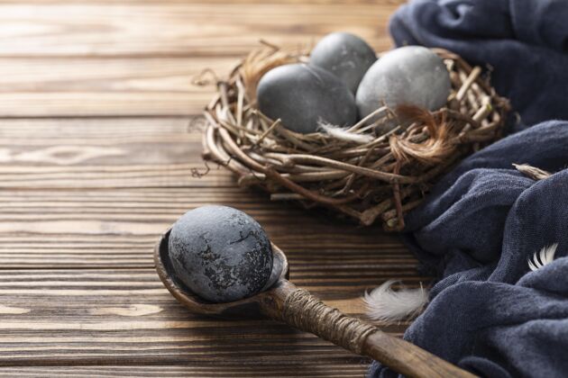 节日高角度的复活节彩蛋在鸟巢里用纺织品和木勺树枝节日鸡蛋