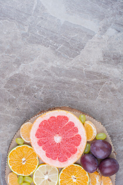 葡萄柑橘类水果 李子和葡萄放在木片上天然美味顶视图