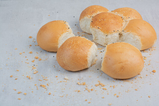 面包大理石背景上的圆形新鲜白面包烘焙面包片糕点