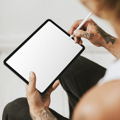 屏幕在平板电脑屏幕模型上工作的纹身男人正方形男人手