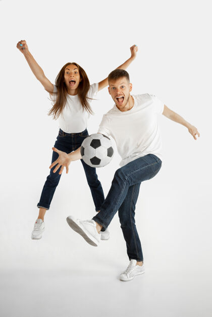 哇美丽的年轻夫妇的肖像在白色工作室背景上孤立面部表情 人类情感 广告  体育概念男人和女人踢足球或足球的行动女孩惊人奇迹