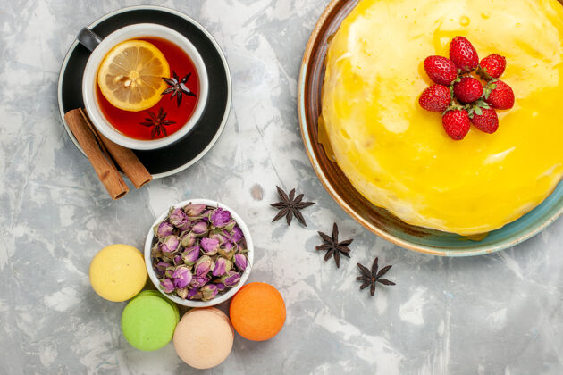 顶部俯瞰美味的水果蛋糕加上黄色糖浆和一杯白茶蛋糕饼干甜甜的糖烤茶饼干糖浆杯子鸡蛋