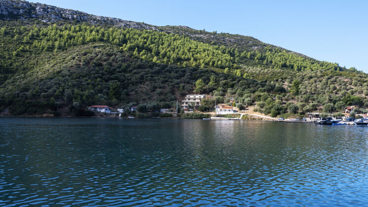 希腊靠近水面的建筑物和停泊的船只 绿树成荫 绿山成荫 希腊游艇海洋旧的