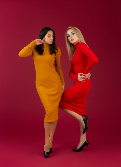 配件穿着黄红色秋冬时尚针织连衣裙的时尚女性在红墙上摆出孤立的姿势时尚衣服毛衣