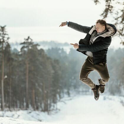 跳跃冬天 人们在大自然中跳到户外 指着复制空间快乐人冬天
