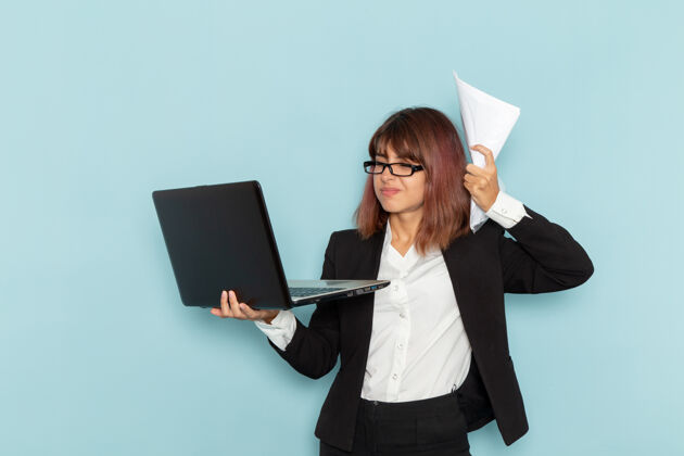 商务女性正面图蓝色表面上拿着纸和笔记本电脑的女上班族秘书办公室手持