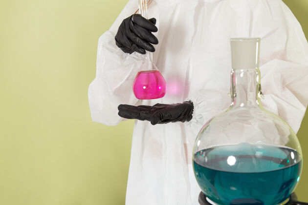 防护前视图穿着特殊防护服的女化学家在浅绿色表面处理溶液工人化学女性