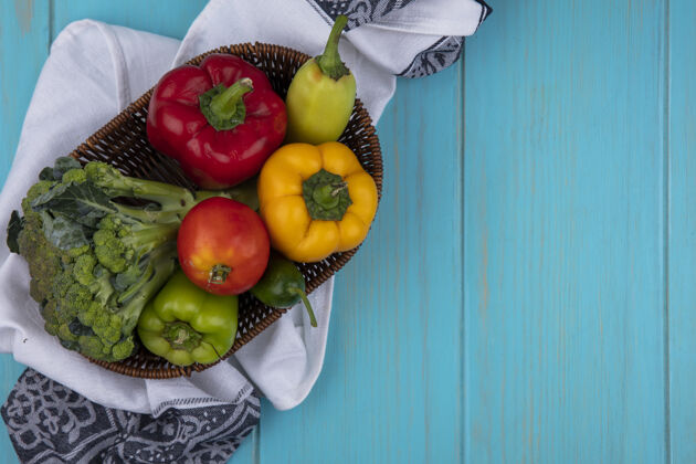 上衣顶视图复制空间番茄黄瓜和甜椒与花椰菜在一个蓝绿色背景的厨房毛巾篮子食物胡椒绿松石