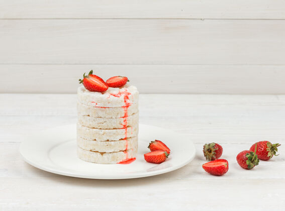 早餐高角度观看白米饼与草莓在白色木板表面板米糕甜点板