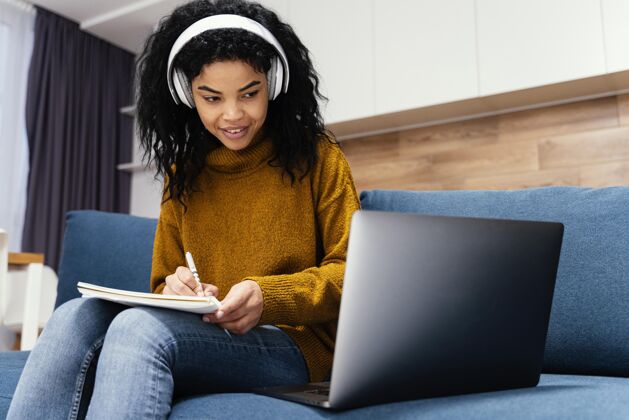 青少年快乐的少女与耳机在网上上学笔记本电脑年轻耳机
