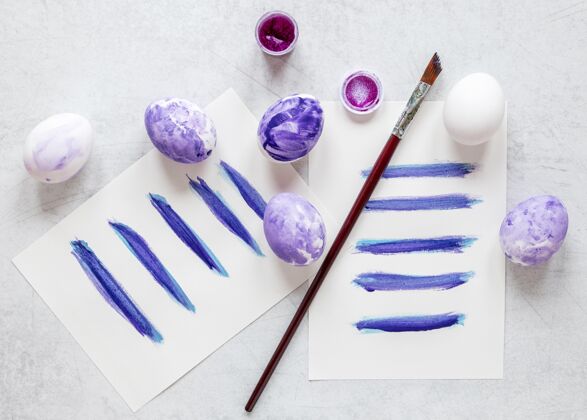 鸡蛋彩蛋与粉彩紫罗兰色复活节平铺食物五颜六色