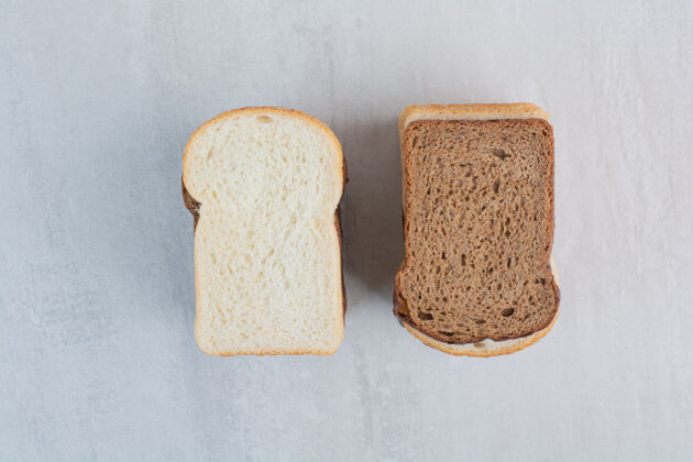 美味新鲜的白色和棕色面包片放在大理石背景上烘焙面包面包片