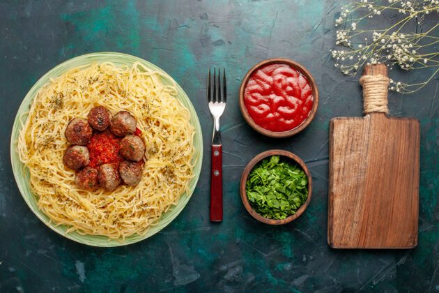 意大利俯瞰美味的意大利面食 配肉丸子和番茄酱 背景为深蓝色面团面食晚餐生的晚餐蔬菜