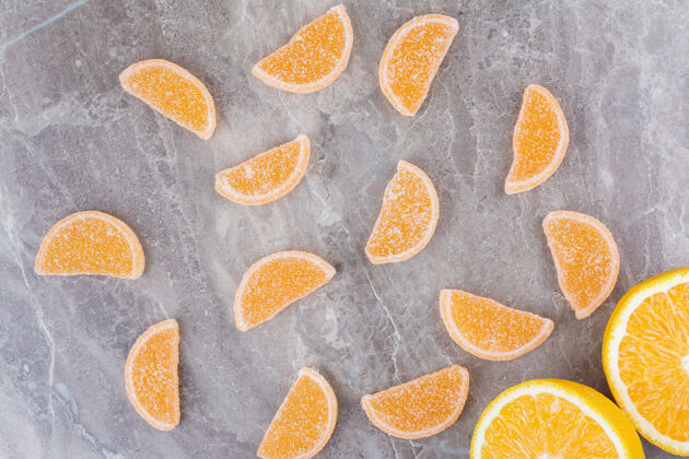 橘子新鲜的橘子片和甜甜的果酱放在大理石背景上果冻甜味糖果