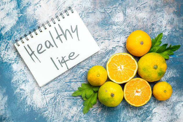 新鲜的柑橘顶视图新鲜的柑桔切花柑桔健康的生活写在蓝白色的记事本上多汁柑橘柠檬