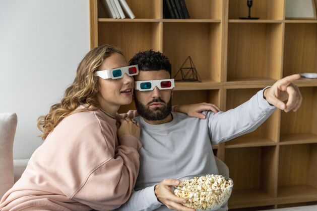 迷恋夫妻俩在家里戴着立体眼镜看电影 吃爆米花爱浪漫爆米花